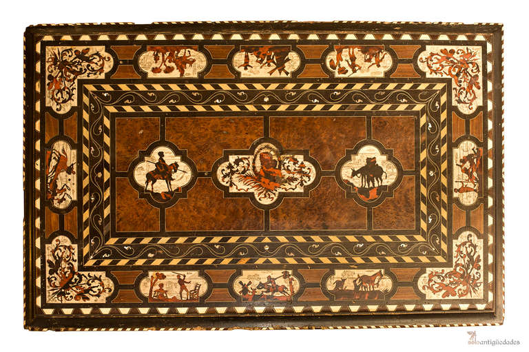 Valuable Spanish table with exclusive scenes of Don Quixote, masterpiece of the Golden Age (17th century) framed geometric fretwork and plant decoration in the corners and center. It rests on four turned legs with ebonised wood joined with iron foot