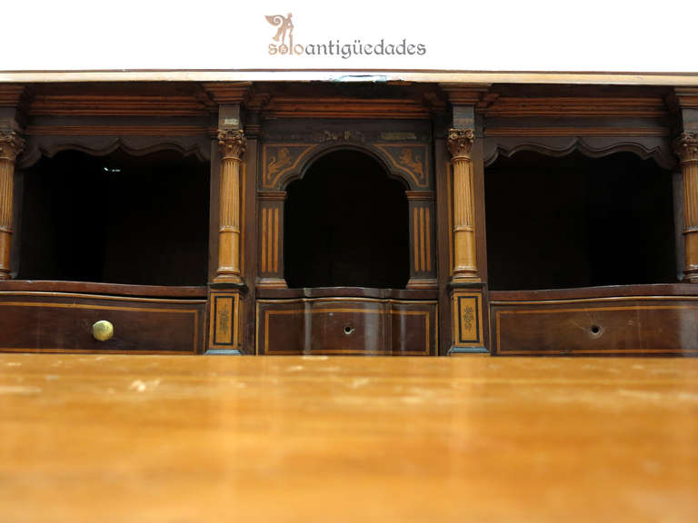 Mahogany Georgian bureau dating from the 18th century. It has hinged lid with marquetry decoration made lobular five lower drawers and curved profile. Desk drawers elegant with exquisite portico and two pilasters that hide secrets.