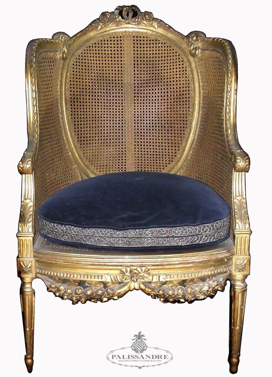 Louis XVI style armchair made of gilded wood decorated with tassels and garlands in relief, with seat and back drafts.