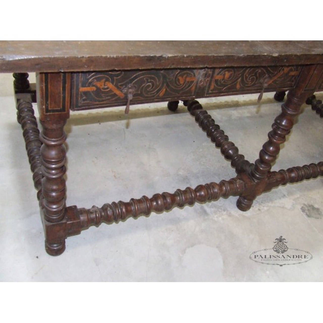 Dining table made large walnut. It consists of a large board which is supported on eight turned legs that are joined together by “chambranas” also turned. It has several drawers with inlaid decoration in gable based foliate scrolls and elongated