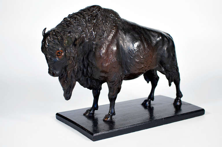 1890 buffalo made out of paper in stunning beautiful shape. although just brown, he has a adorning polychrome surface and red circled eyes to let him look like testosterone filled, but his attraction is more blandly and joy-filled like a lamb