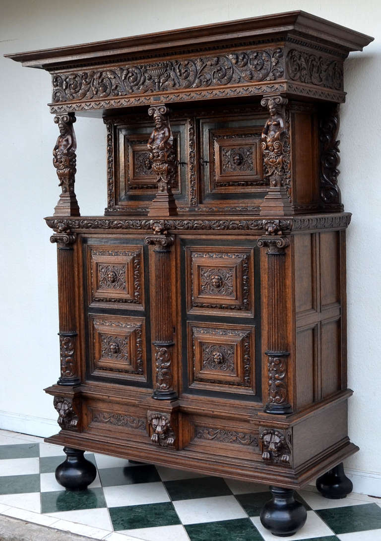 Rare Baroque cabinet from Northern Germany is made from solid oak wood.
The elegant base is decorated with lion heads and the front is architecturally structured. The coffered doors are richly adorned with fine wood carvings and angel heads. This
