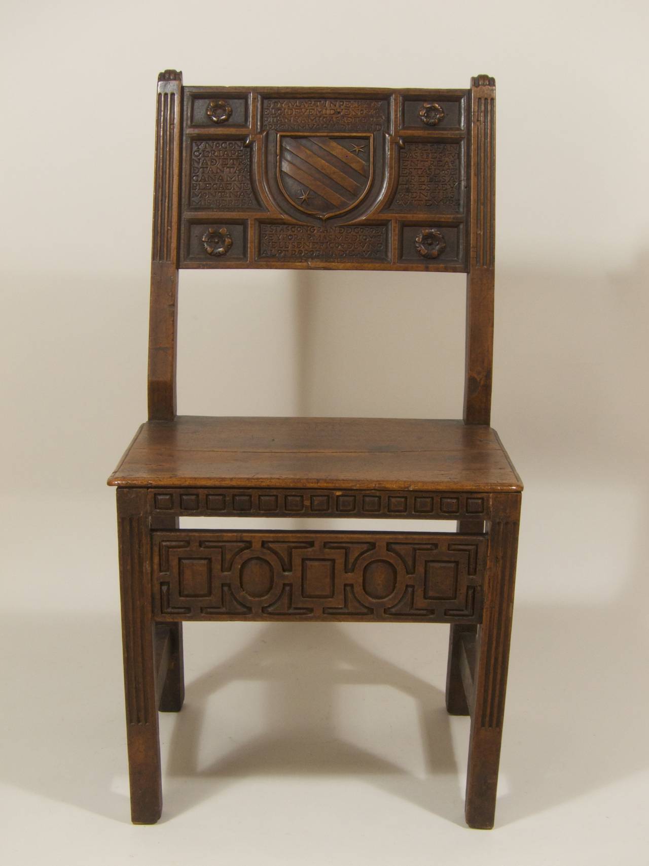 A Renaissance chair (silla), Spain, 16th century, walnut, construction partially fluted, with carved ornaments, a cartouche to backrest, inscribed:

A Soy Martin Pelayz Y El Cid Fuemi Duendo Y Capitan Y Mi De Teran Ore En Mucha De La Lid. B Y No Con