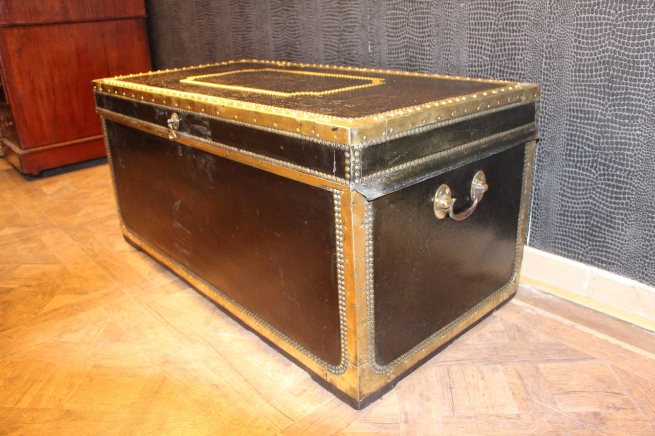 This piece of luggage is very elegant;
Its frame is made in camphor wood.Its exterior is black leather with contrasting brass trim and studs.
It has got a very warm patina and its interior is naturally camphor parfumed.
It could be perfect as a
