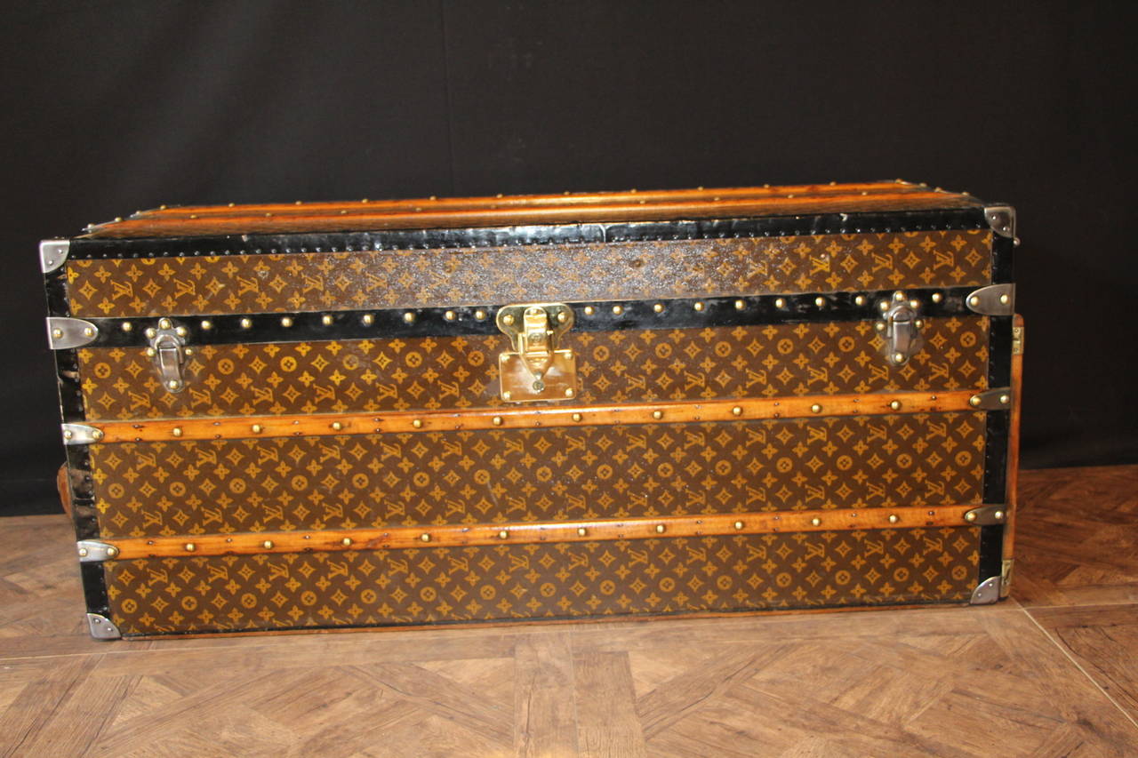 This spectacular stenciled monogramm steamer trunk features black steel trims,brass lock and studs .
Its length is very unusual and it could be used as a very large coffee table.
Its interior is clean and fersh, originally lined in grey fabric and