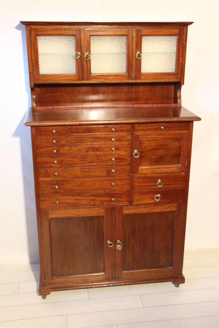 This very unusual dentist cabinet is fitted with 3 glazed compartments on the top ,then a multitude of small drawers.Some have white opaline bottoms,some have small compartments.
Underneath,there are 2 plain doors.