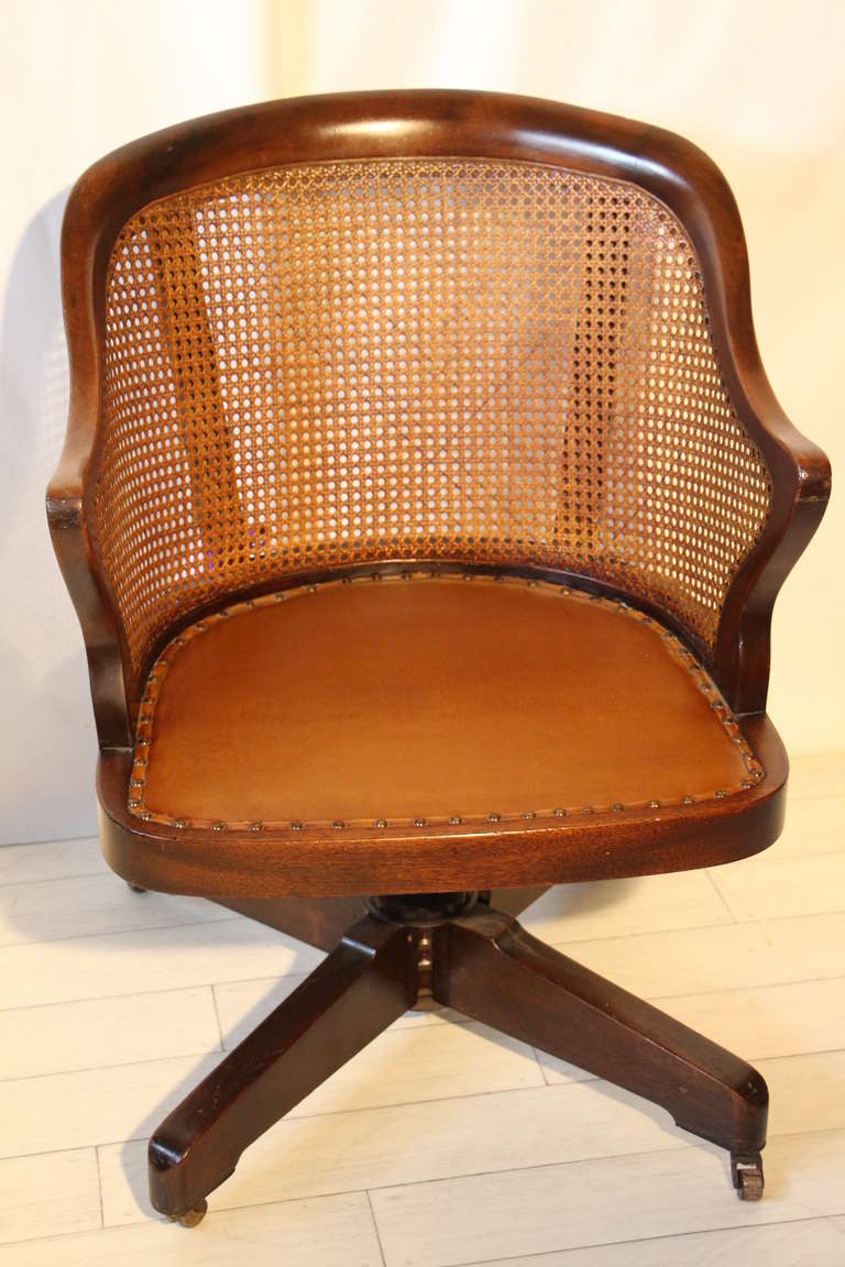 This very comfortable chair is made in mahogany and has canned back.It has got adjustable height with swivel.