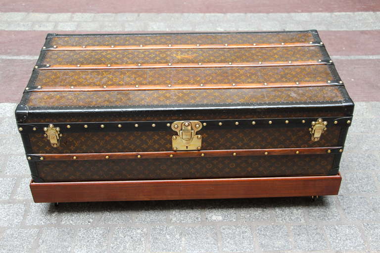 This Louis Vuitton trunk is stenciled monogramm canvas and black leather trim.
It has brass hardware and has a beautiful patina.
A base has been made on purpose to have it higher and to be used as a coffee table or end of a bed.
With the base,the