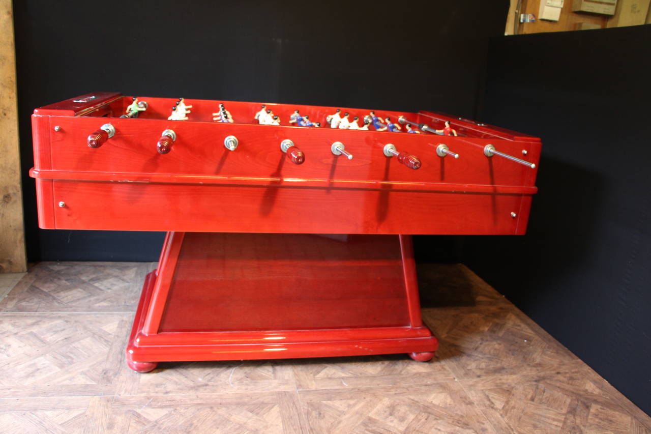 This foosball table is very impressive due to its size and to its cast metal players that have two legs and two arms instead of only one block.
Original red lacker finish.
Moreover, thanks to its sloped paying surface, the ball is always in