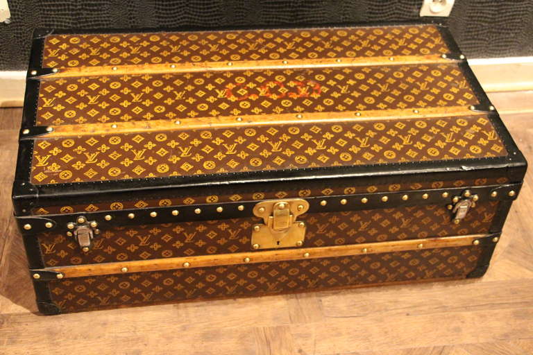 This Louis Vuitton trunk is stenciled monogram canvas and black leather trim. It has brass hardware and has a beautiful patina. It has got its original interior with its removable tray. A base has been made on purpose to have it higher and to be