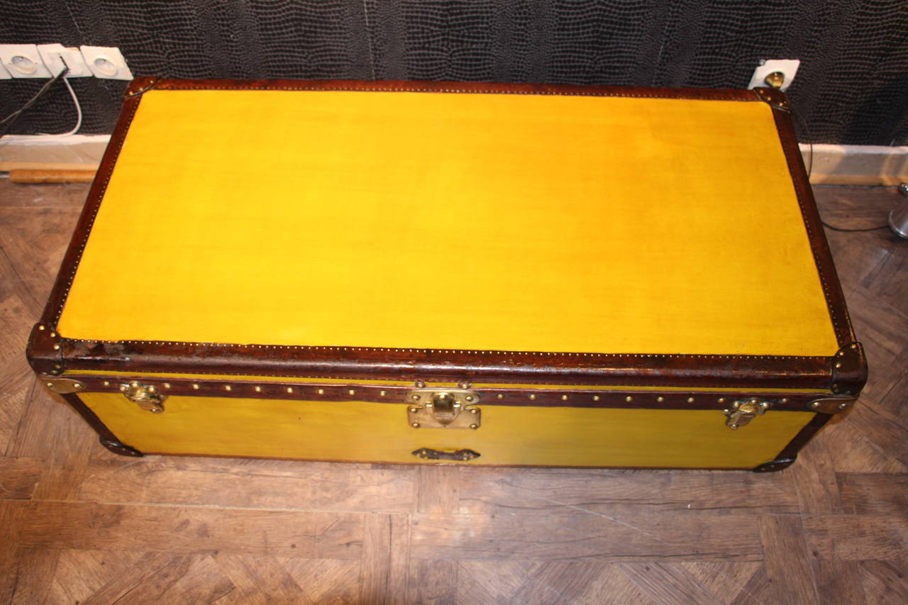 This very rare yellow steamer cabin trunk features leather trim and handles as well as brass locks. It is very elegant.
Its interior has kept its original beige lining with its removable tray. It is nice and clean.