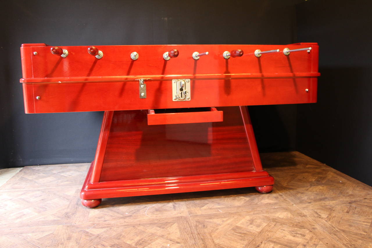 This foosball table is very impressive due to its size and to its cast metal polished players that have two legs and two arms instead of only one block.
Original red lacker finish.
Moreover, thanks to its sloped paying surface, the ball is always
