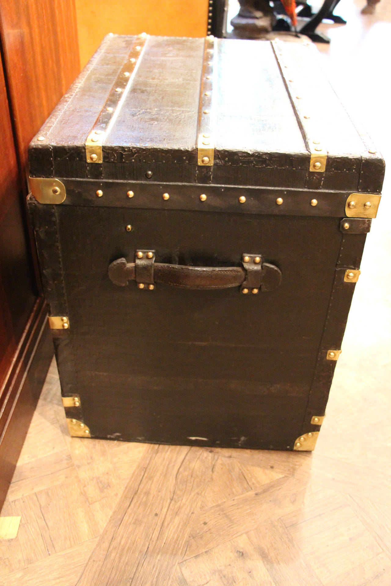 This steamer trunk has got very elegant proportions and could be used as end of a sofa or bedside cabinet. It features steel trim, black canvas, brass fittings and lock and leather handles.
Its interior has been relined around 10 years ago and is