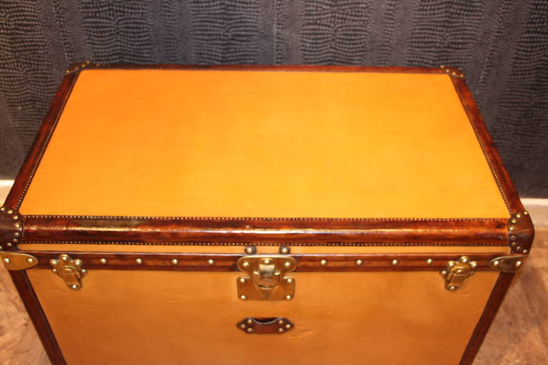 This unusual orange Vuittonite canvas hats' trunk has got all leather trim and handles,brass corners and locks;It has a beautiful warm orange patina.
The interior is perfectly original with beige linen and features two original webbed baskets.It is