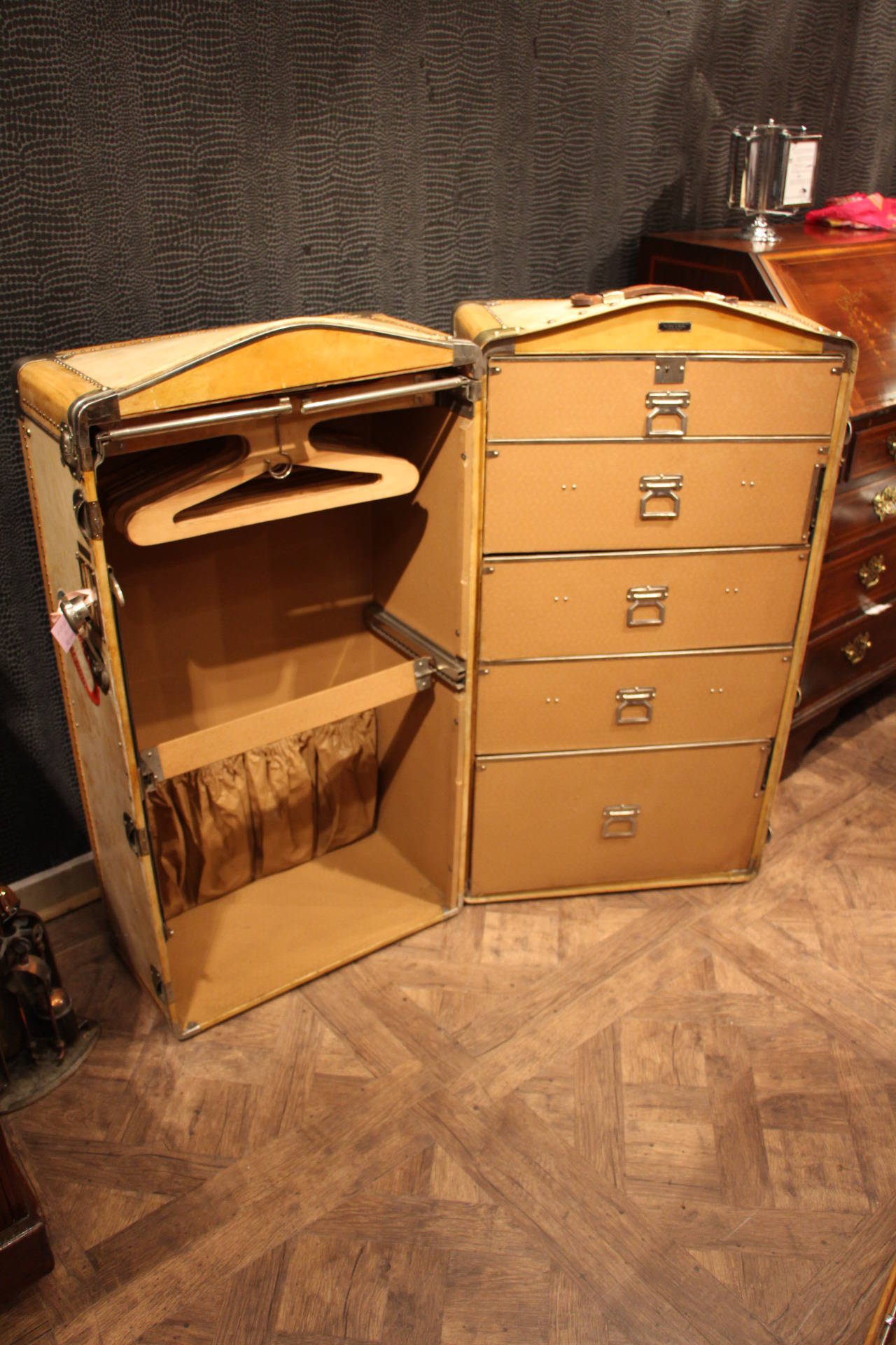 This vellum trunk has got a very clean and fresh interior composed of a folding hanging section with a series of hangers and a five-drawer chest.
It has got a very nice exterior patina with brass fittings and a large brass main lock.
Free shipping