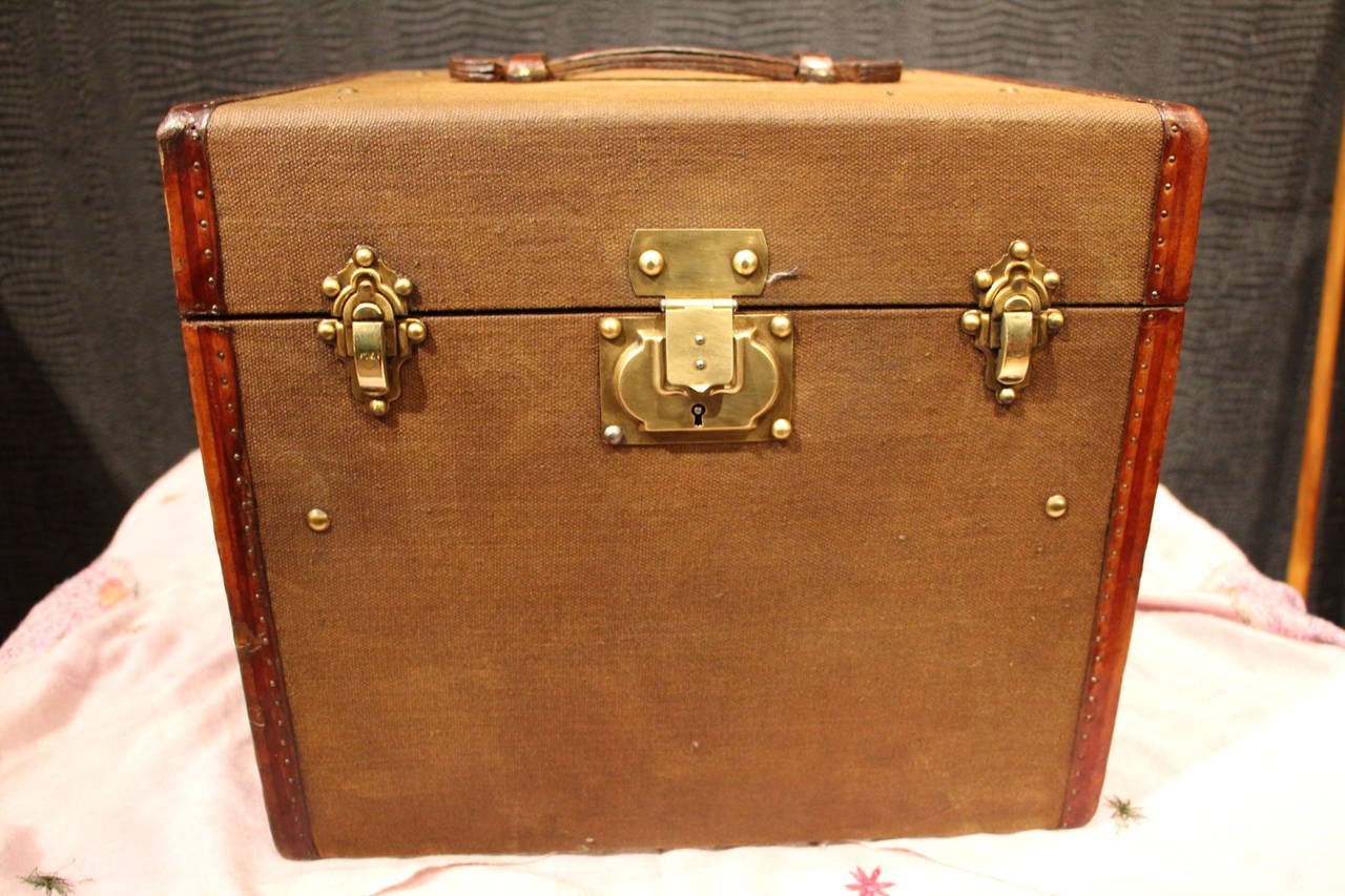 This canvas hatbox features leather trims and handle as well as brass locks.It is a very decorative piece that can also be used for storage as its interior is all original and in very good condition.