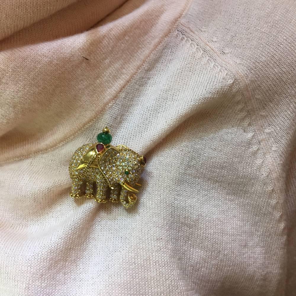 Diamond Emerald Ruby Gold Elephant Brooch
Finely made with top quality full cut diamonds, emerald bead and rubies set 18kt yellow gold

1 1/4 inches diameter