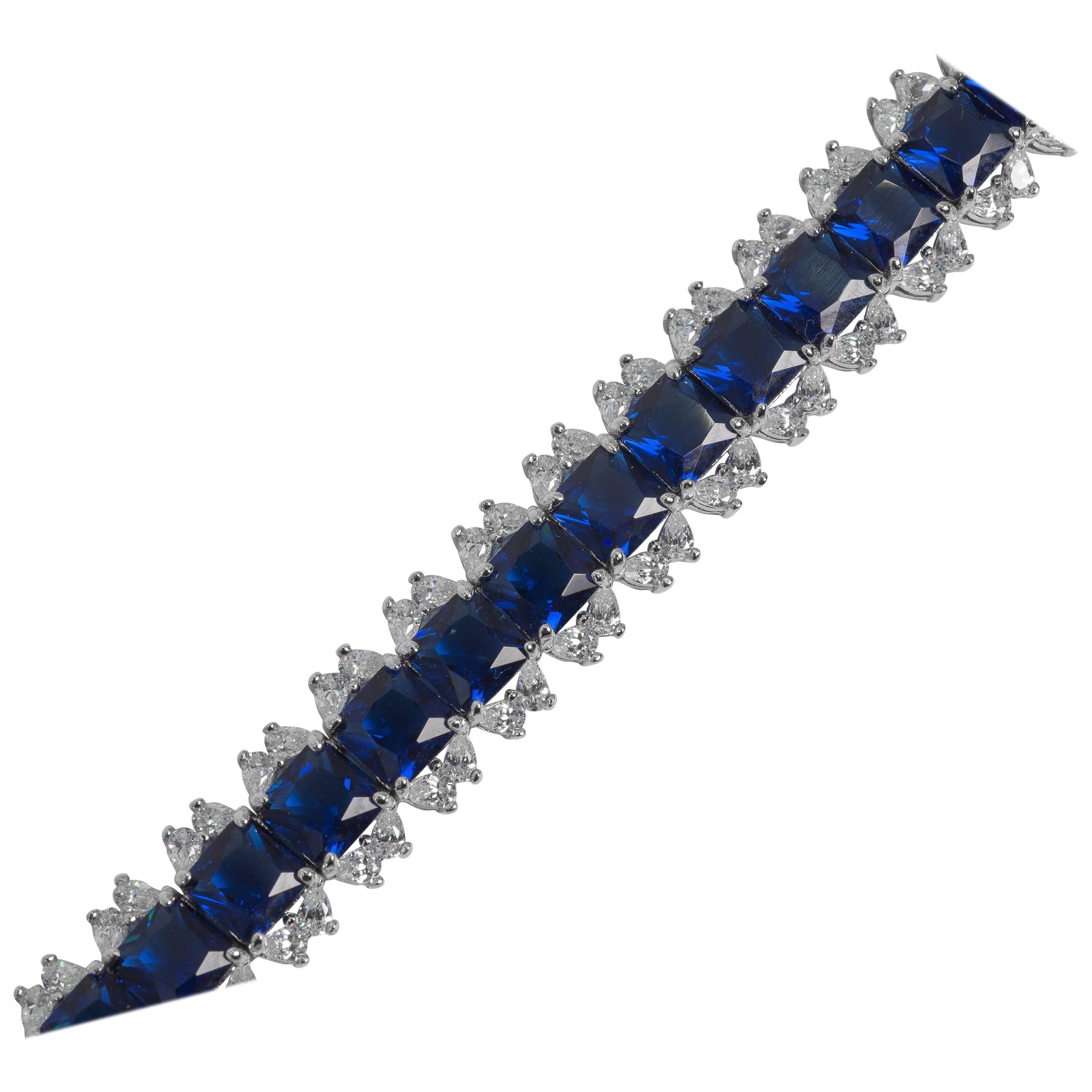 Straight line bracelet of man made 1 carat Burma sapphires edged with cubic zirconia totally flexible secure clasp hand set in rhodium sterling seven inches long by half inch wide.