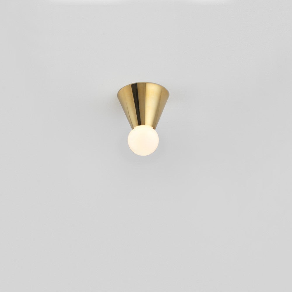Michael Anastassiades' Cone Light, available in a wall and ceiling option, displays a single bulb inside a polished brass, cone-shaped base. 

Bulb Specifications: G9 -35 Watt frosted halogen bulb
Supplied with 4