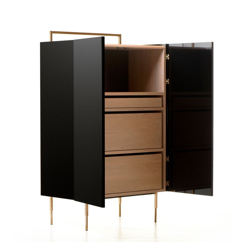 Trunk Tall Cabinet is a utilitarian design in stunning, luxurious materials. The lacquer body, mirror polished by hand, opens via a concealed pull on the doors to reveal three drawers in premium solid hardwood. The legs and frame are solid brushed