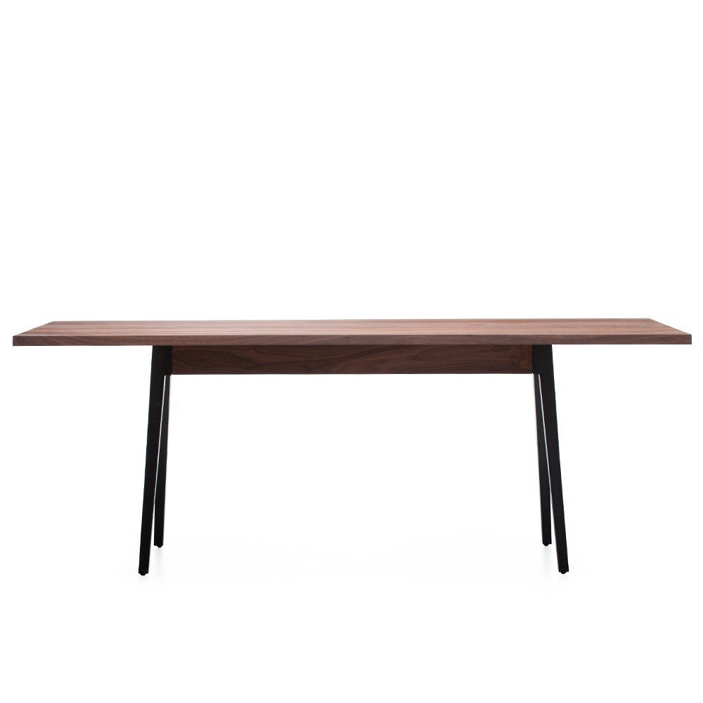 Welles Table makes generous use of solid wood with an elegantly simple form. The tabletop, detailed with a central divide and angled edges, is set upon cast iron legs. This table is quietly functional while remaining approachable and appealing to
