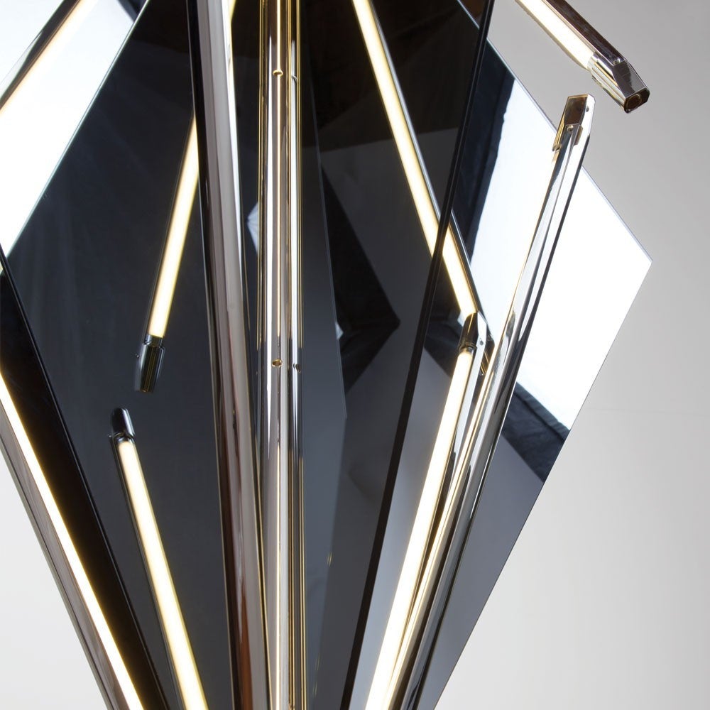 Echo uses fins of mirror radiating from a central axis to reflect beams of light. LED tubes are turned inward to bounce off the glass; the light becomes both softened and multiplied. Also available with fins of glass which diffuse light and softly
