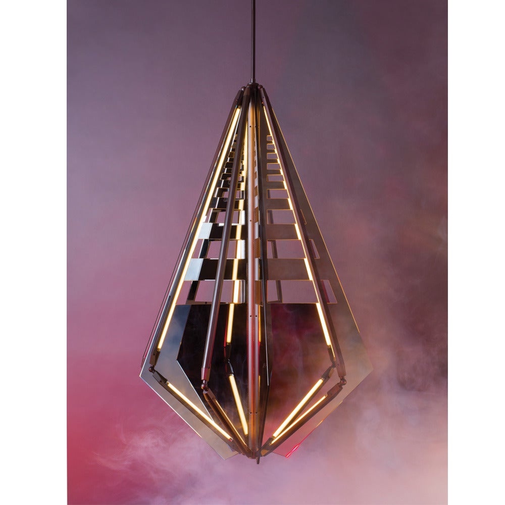 Echo uses fins of mirror radiating from a central axis to reflect beams of light. LED tubes are turned inward to bounce off the glass; the light becomes both softened and multiplied. Also available with fins of glass which diffuse the light and