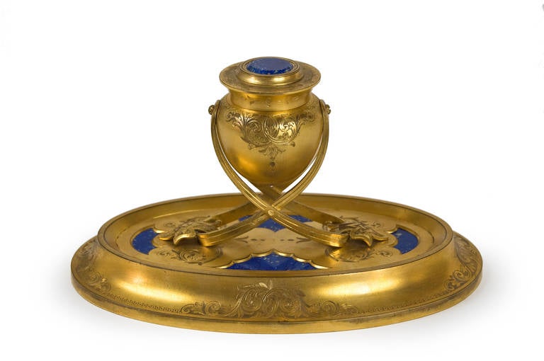 Gilded bronze inkwell engraved and adorned with Lapis Lazuli.

Attributed to Maison SamsonWertheimer. Engraved signature of the seller 'T. W. Hopkins 22, New Bond Street' on the ink reservoir.

This inkwell very specific shape and engraved decor