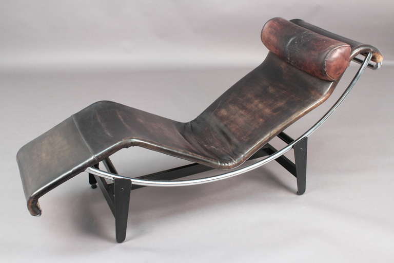 This early production of the classic LC4 chaise lounge by Le Corbusier in a beautifully patenated black leather, has inward facing feet, a slightly tapezoid seat shape and a narrower end. Chrome frame is mounted on a matte black steel base.