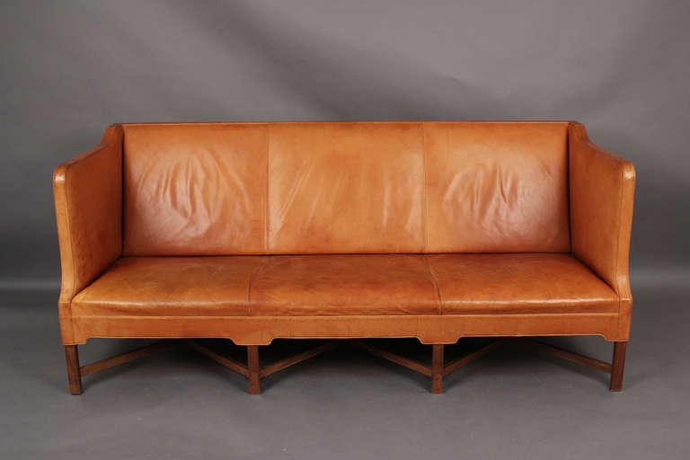 Large freestanding sofa by Kaare Klint with eight cross framed profiled legs in mahogany. Sides, seat and back upholstered in beautifully patinated 
natural colored leather. Model 4118. Made in 1978 by Rud. Rasmussen Cabinetmakers Copenhagen.