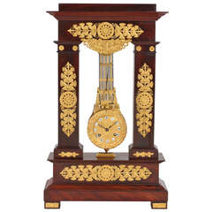 A French late-Empire mahogany and ormolu oscillating mantel clock, circa 1820.