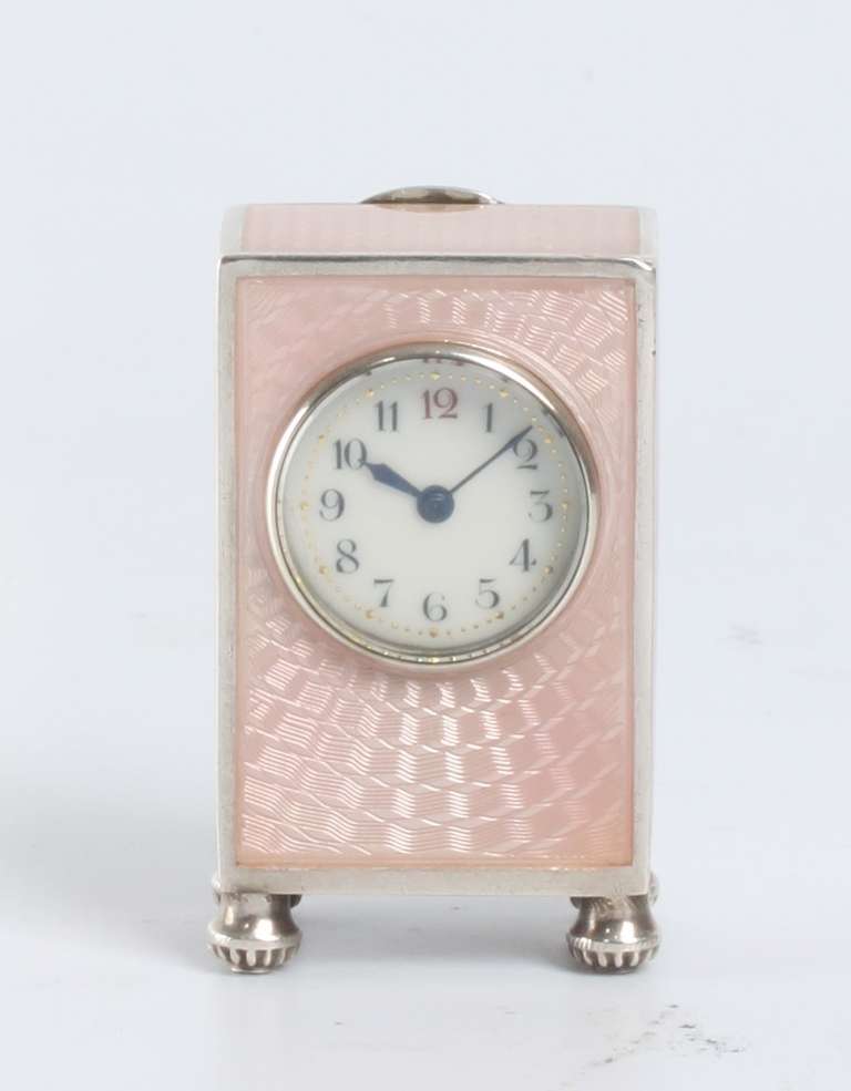 1.7-cm enamel dial with Arabic numerals and gilt minute marks, blued steel hands, spring-driven movement with anchor escapement, rectangular silver case with geometrical guilloche engraving under pink translucent enamel, raised on gadrooned feet