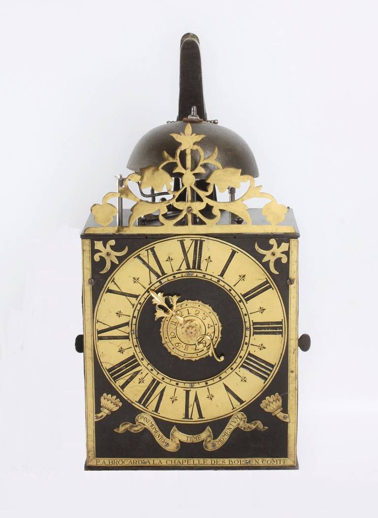 17.6 cm iron dial with brass lining signed below P.A. Brocard A La Chapelle des Bois en Comte, applied brass chapter ring with Roman numerals, pierced brass hour hand and engraved alarm disc, brass spandrels and shutters with engraving Omni Momento