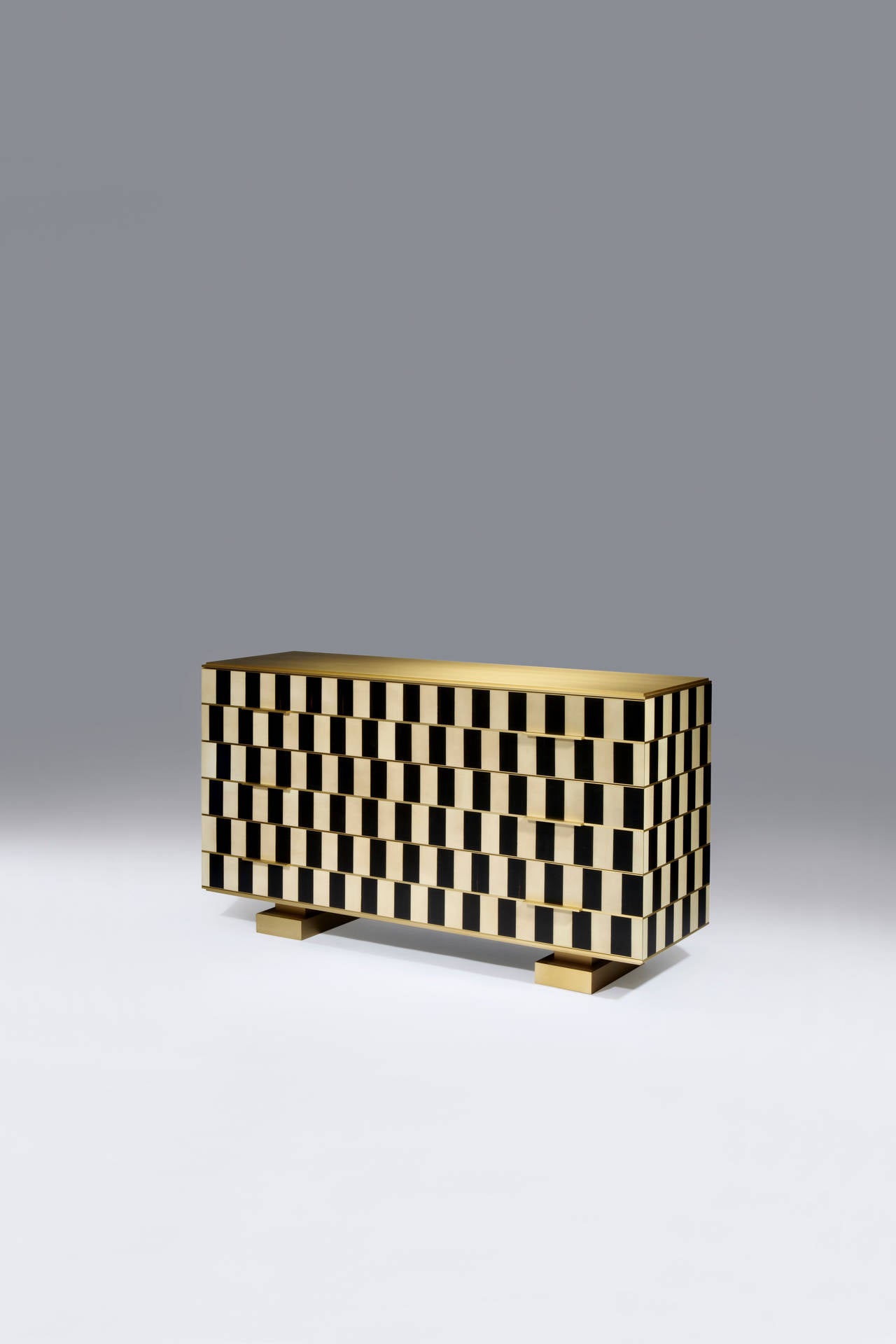 OP ART Chest of Drawers
Dimensions: 1560 x 480 x 890 mm (height x width x depth).
Finish: Sycamore veneer, full-pore satin varnish.
Ebony veneer, full-pore satin varnish.
Light patinated brass.
resting on two brass-plated legs.Above, a box made of