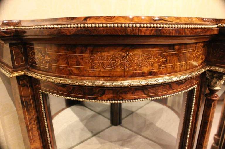 A beautiful burr walnut Victorian Period antique credenza. Having a shaped top veneered in beautifully figured burr walnut, with geometric boxwood line inlaid detail and an ormolu beaded edge. The frieze with typical Victorian arabesque marquetry