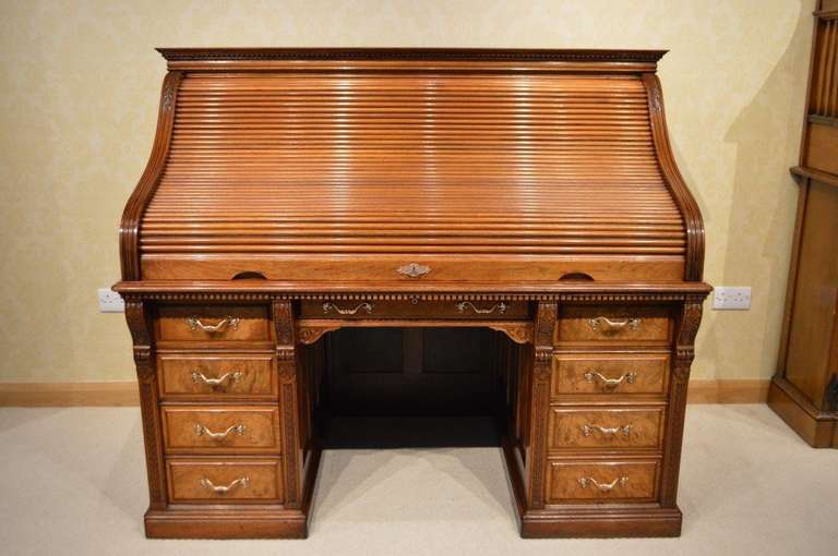 A Good & Rare Walnut & Burr Walnut Late Victorian Period roll top desk by Shannon Ltd. The upper section with a solid walnut rectangular top and dentil moulding above the 