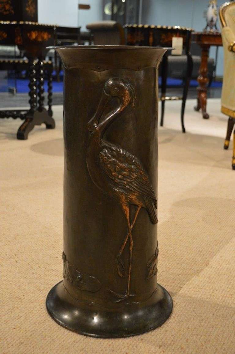An Arts & Crafts Period patinated copper stick/umbrella stand. The flared rim with hand riveted detail. The hand beaton body and with repousse work depicting a stork, fish and a frog on lily pads. English circa 1900-1910

Dimensions: 23.5