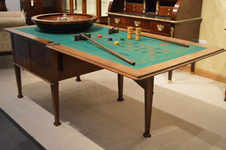 An amusing and rare oak Edwardian Period roulette/games table by J.C Vickery of London. Having a fold over top quarter veneered in 