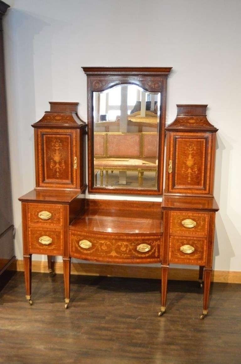 A mahogany inlaid Edwardian Period antique dressing table. The upper section with a central shaped bevelled mirror flanked by twin panelled cupboards each having a central marquetry inlaid Adams style urn, which opens to reveal three velvet lined