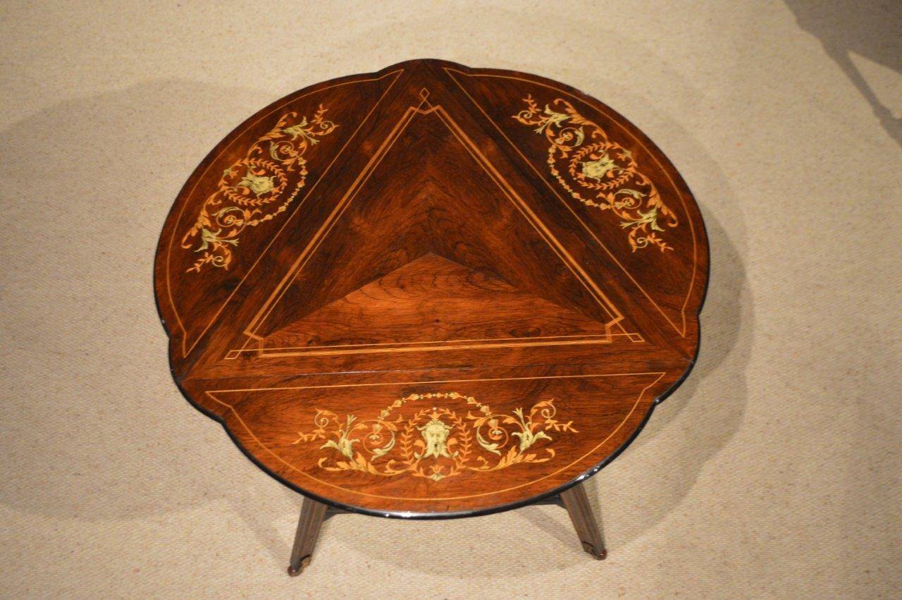 A beautiful rosewood and marquetry inlaid Late Victorian Period triangular drop leaf table. The triangular top veneered in beautifully figured rosewood with geometric satinwood inlaid detail. Having three hinged drop leaves each with floral