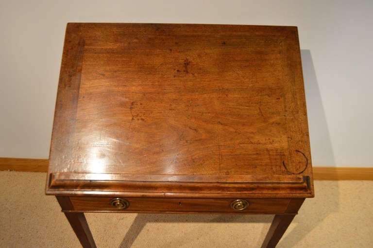 A mahogany George III Period architects or reading table. The rectangular cuban mahogany top which tilts up and ratchets to eight different positions, retains the original mahogany lined frieze drawer with fitted writing slide. With boxwood beading