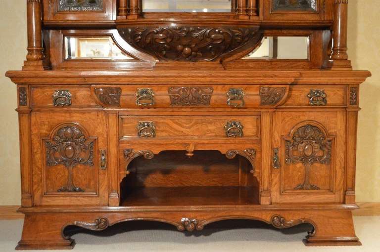 A superb quality pollard oak Late Victorian Period sideboard by Collinge & Co Burnley. The upper section with a central rectangular bevelled mirrored back, flanked by wonderful stained glass leaded doors with Art Nouveau Glasgow School roses. Raised