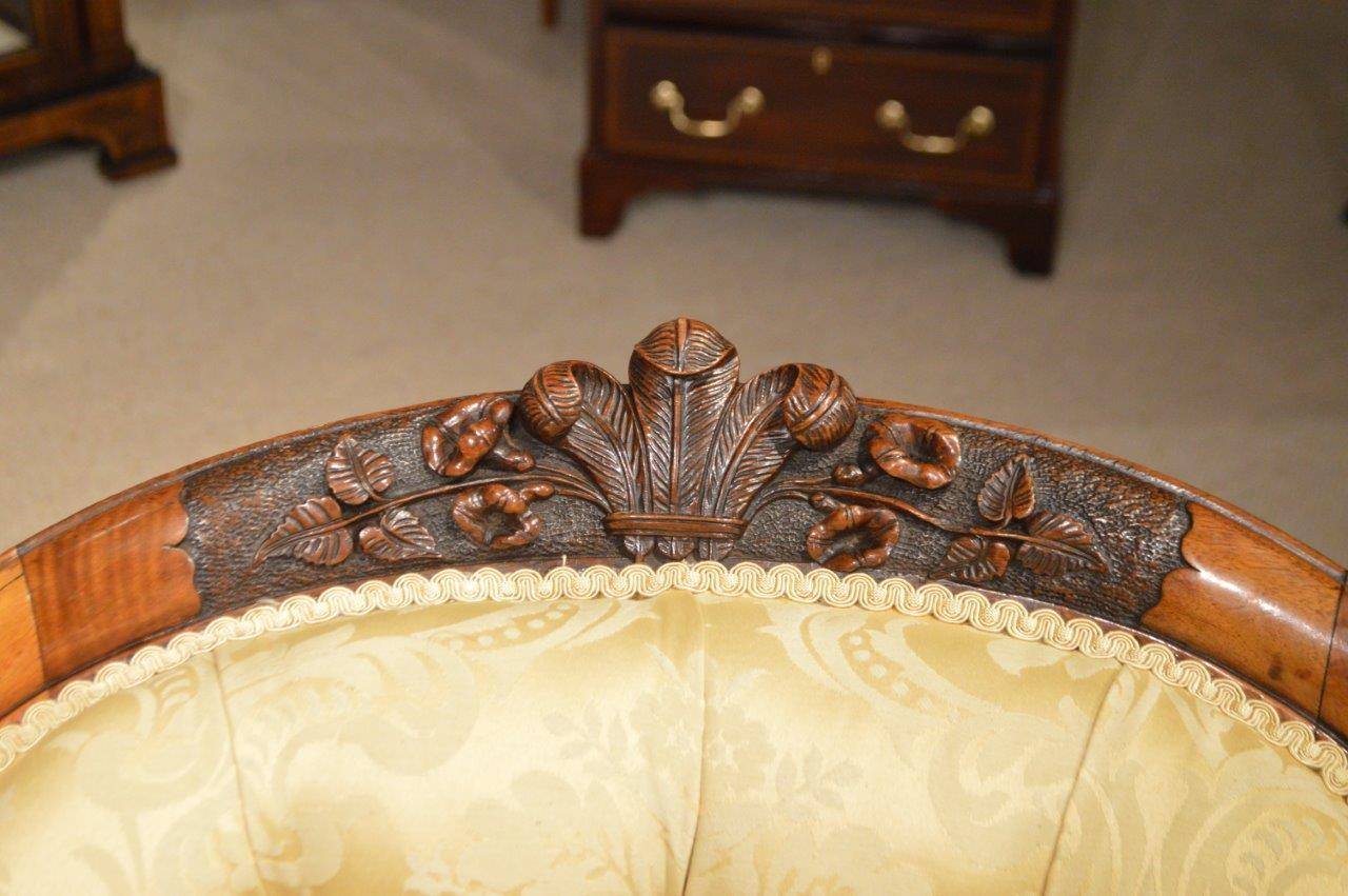 A superb walnut Victorian period antique chaise longue. Having a shaped deep buttoned back with a finely carved top rail depicting the Prince of Wales feathers and foliate detail which is repeated on the lower support rail. The generous sprung seat