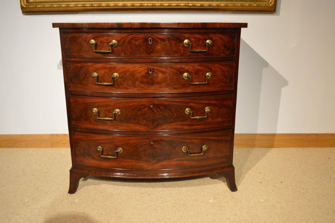 A mahogany Regency Period bow front antique chest of drawers by Gillows Of Lancaster. The bowed top veneered in beautifully figured mahogany with a mahogany banded edge, above an arrangement of four graduating oak lined bow front drawers each