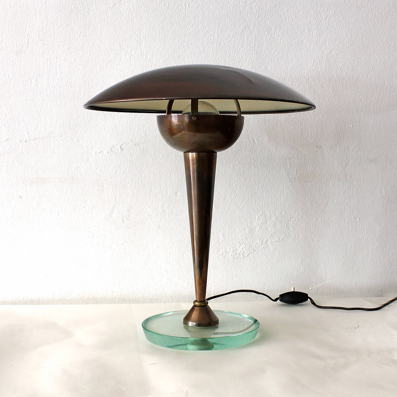 Art Deco desk lamp, brass with original oxidation, thick glass base, pivoting lampshade.
Manufacturer: Stilnovo
Italy c. 1930