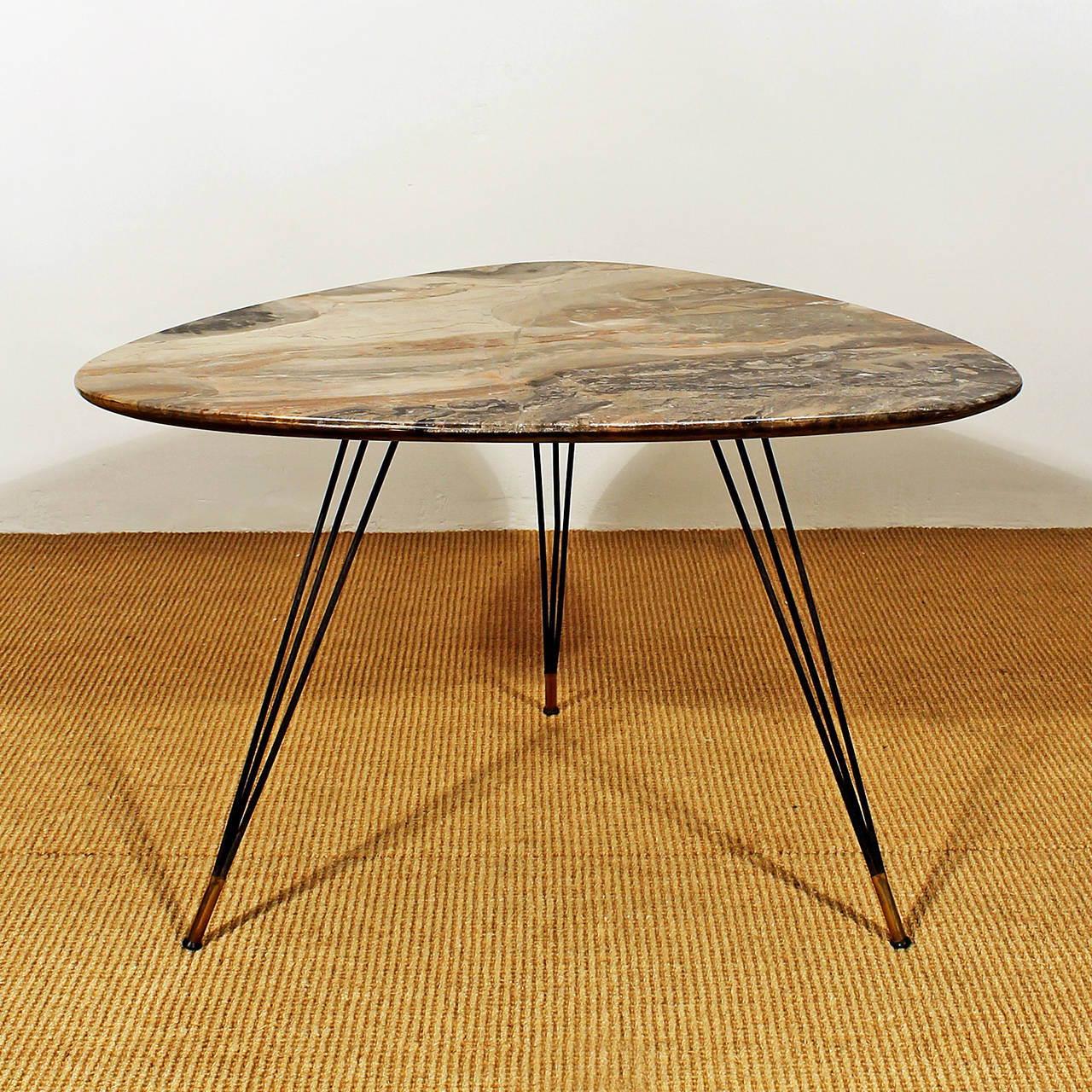 Tripod coffee table, triangular shape, black lacquered iron feet with polished brass at the bottom, spectacular marble on top.

Italy, circa 1950.