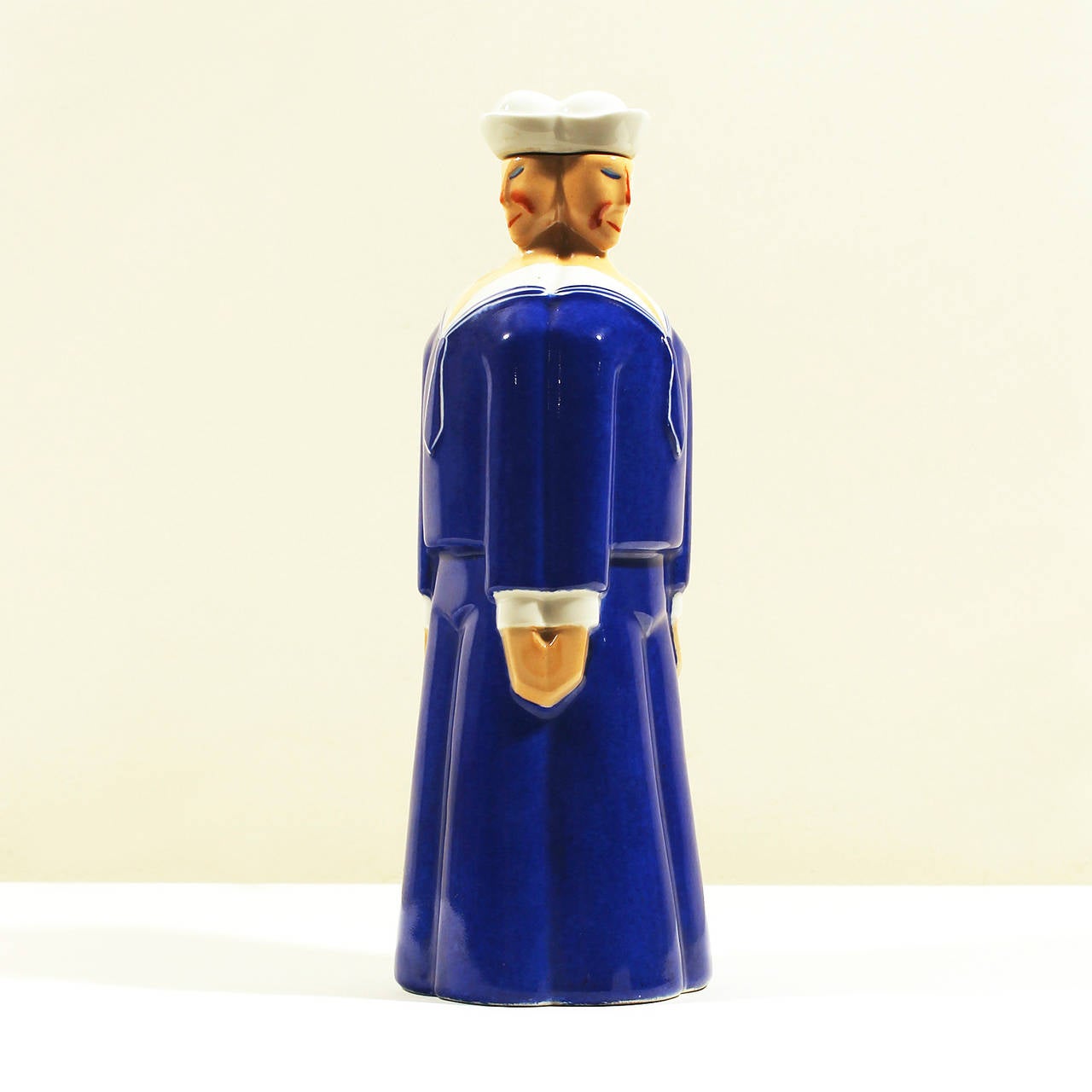Art Deco porcelain decanter, modelled as 3 stylized sailors with the 3 hats lid in blue, white, beige and orange colours.
Printed mark underside: ROBJ - Paris - Made in France.
Manufacturer: Robj 
France c. 1920