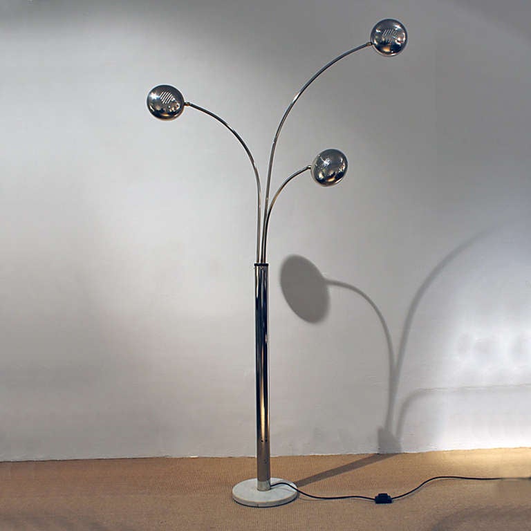 Standing lamp with three movable branches with orientable reflectors, chrome plated metal, white marble base.<br />
Italy, circa 1970