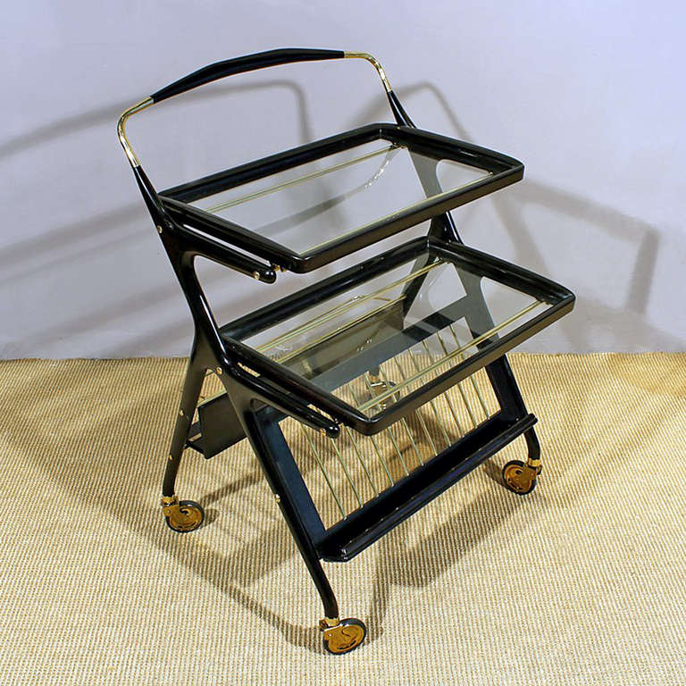 Bar cart, stained and french polished beech wood, brass accessories and glass, bottle holder and magazine rack, two removables trays.<br />
In the style of Ico Parisi <br />
Italy, circa1950