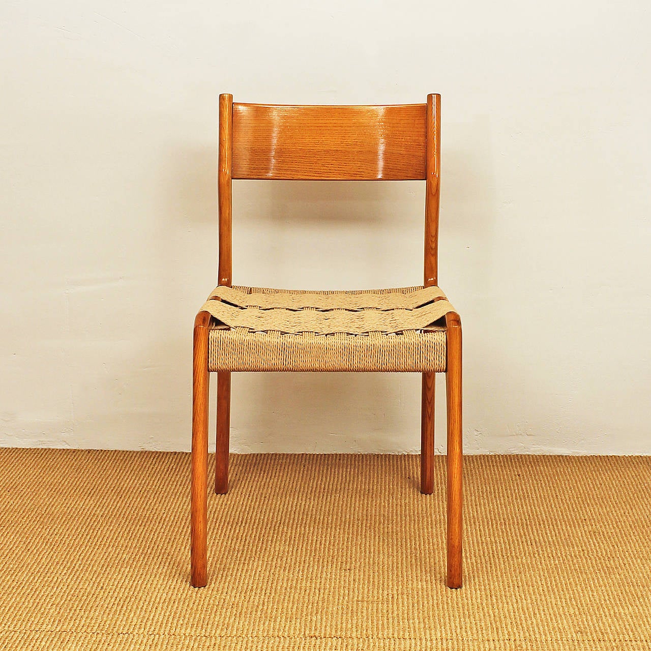 Ten splendid chairs, solid ashwood, French polish, seat re-stringed with natural fiber and the same pattern. Very comfortable, stamped as patented model and manufacturer (illegible) behind the ropes,
Italy, circa 1950.